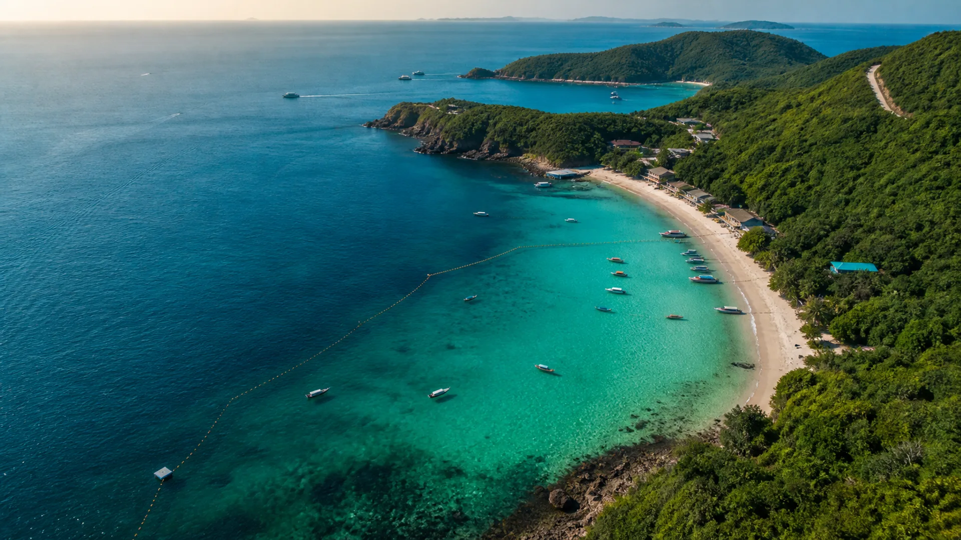 Aerial view of a turquoise bay and green coastline on Koh Larn